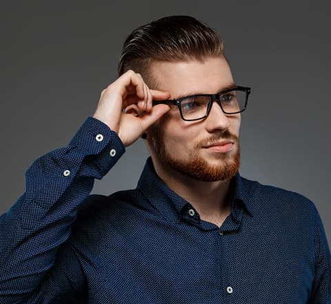 Man wearing black rectangular glasses and a navy patterned shirt