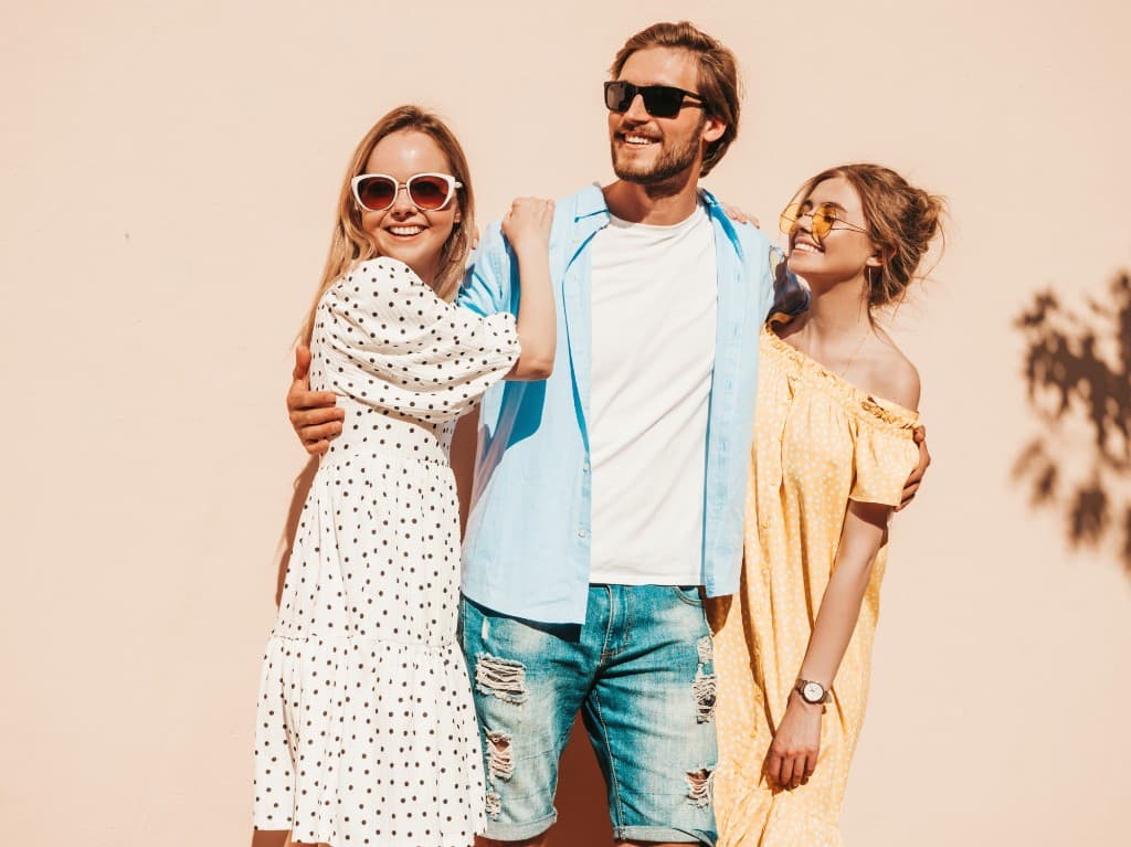Three friends outdoors wearing different styles of sunglasses